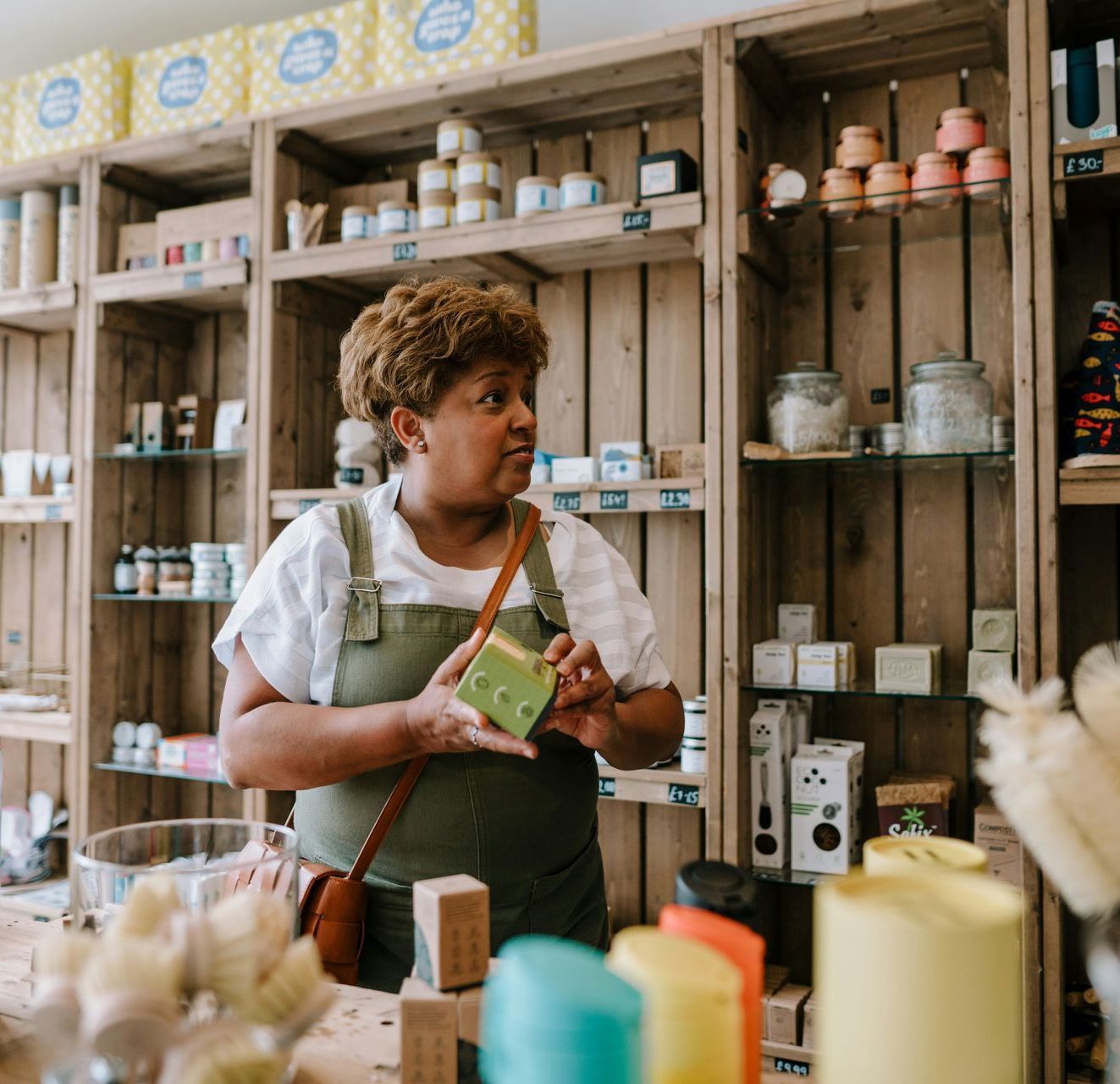 A woman is standing in a store looking at candles