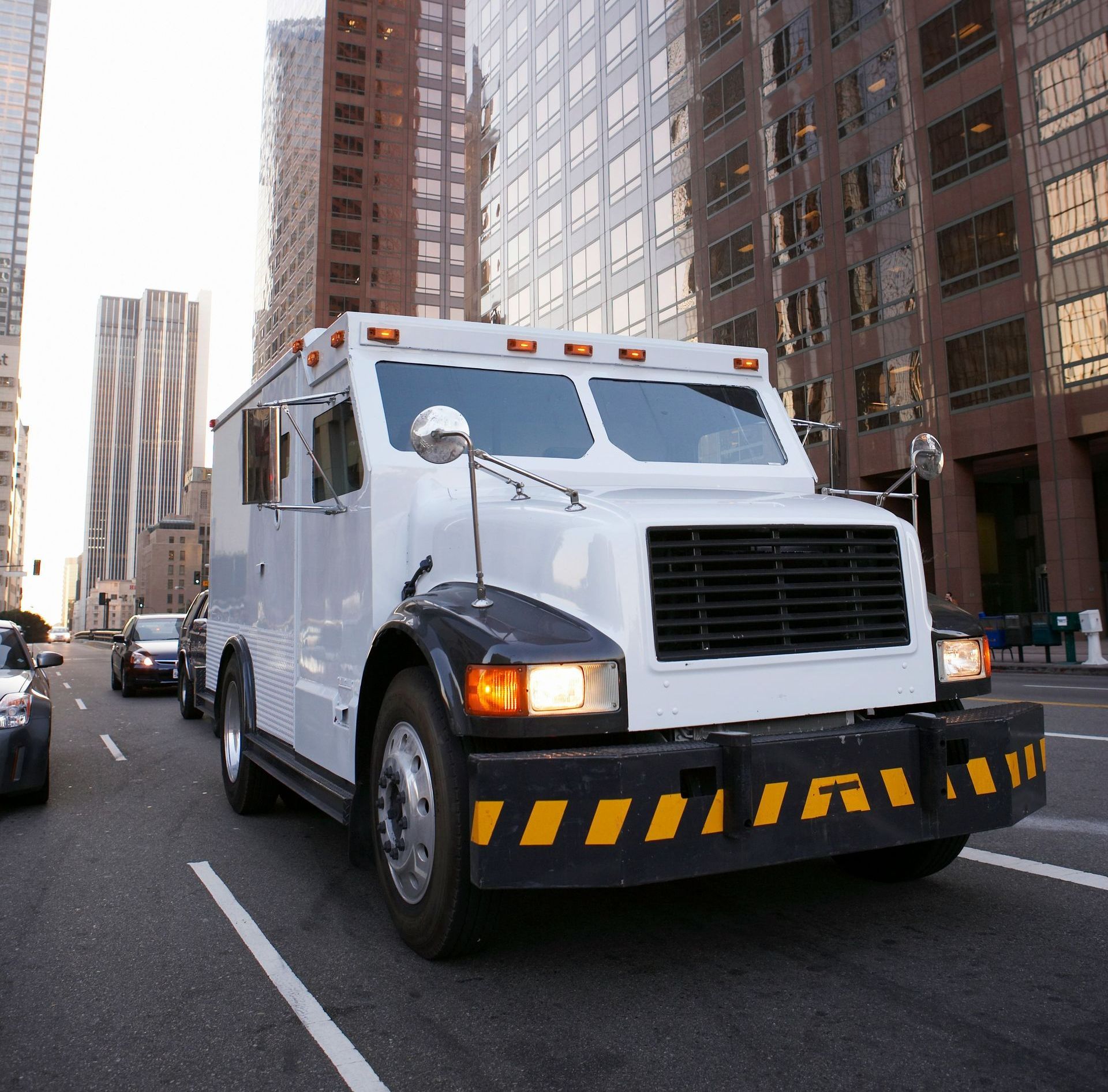 A white truck is driving down a city street