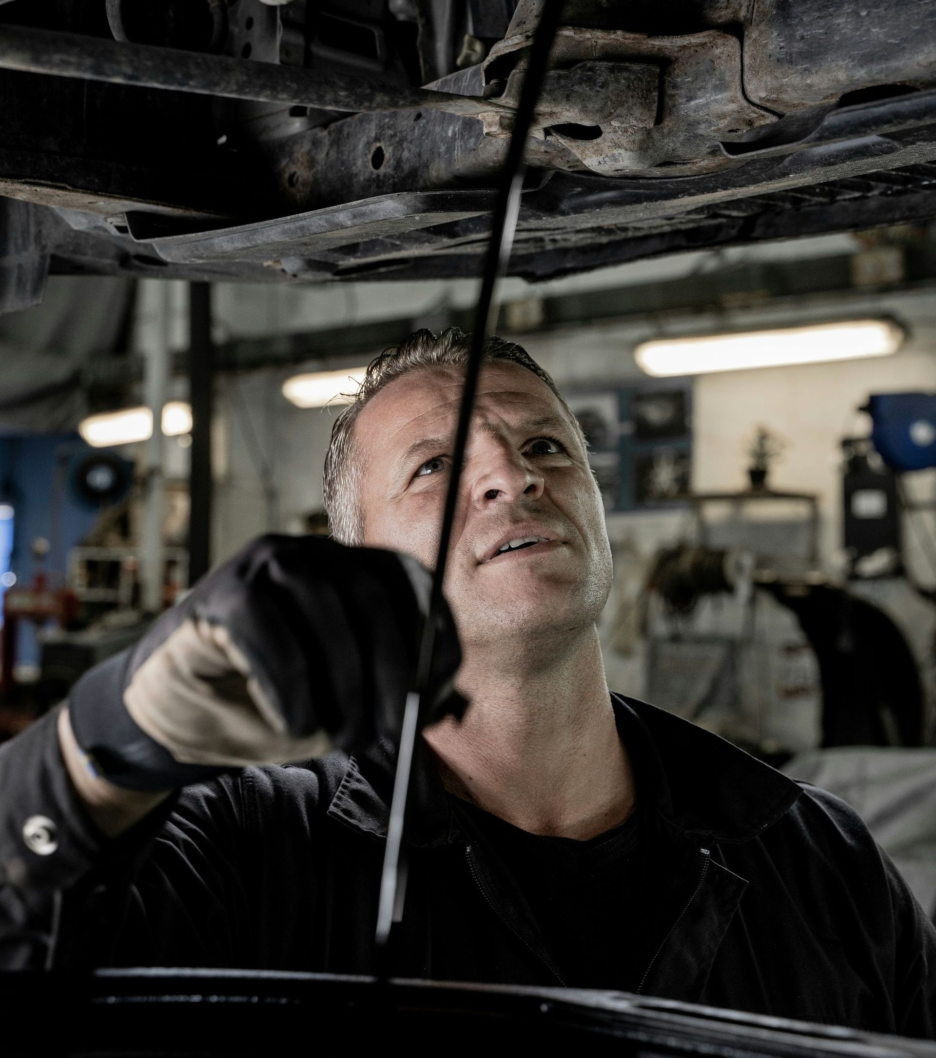 A man is working under a car in a garage