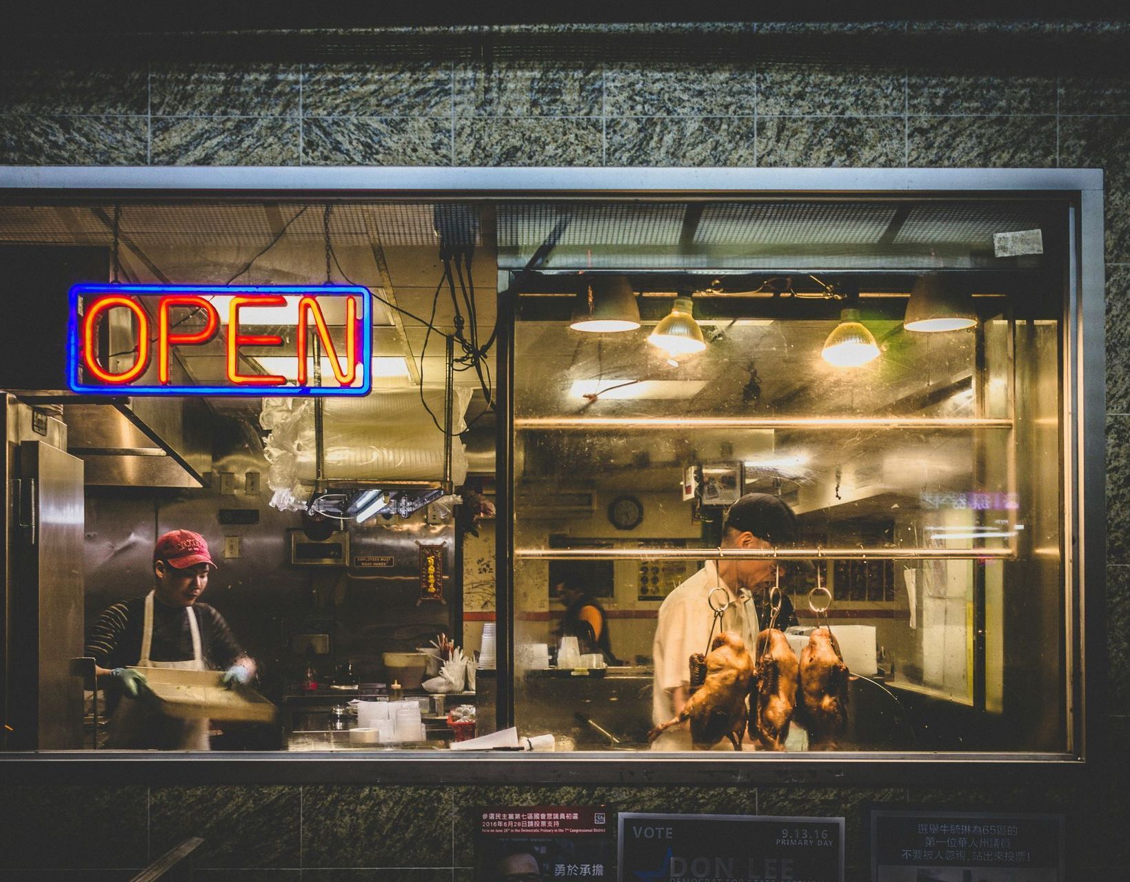 A restaurant with a neon sign that says open