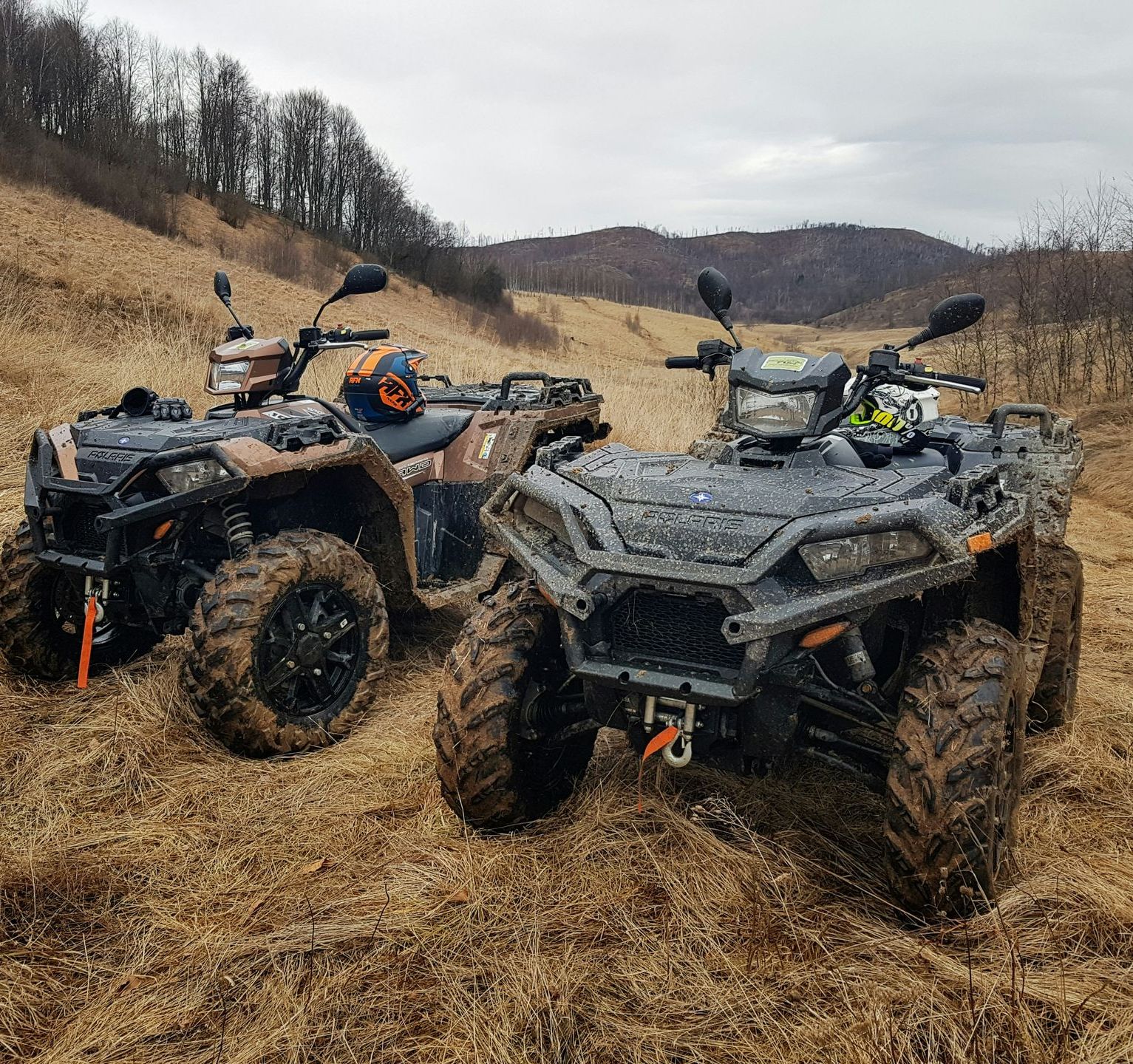 Two atvs are parked next to each other in a field.