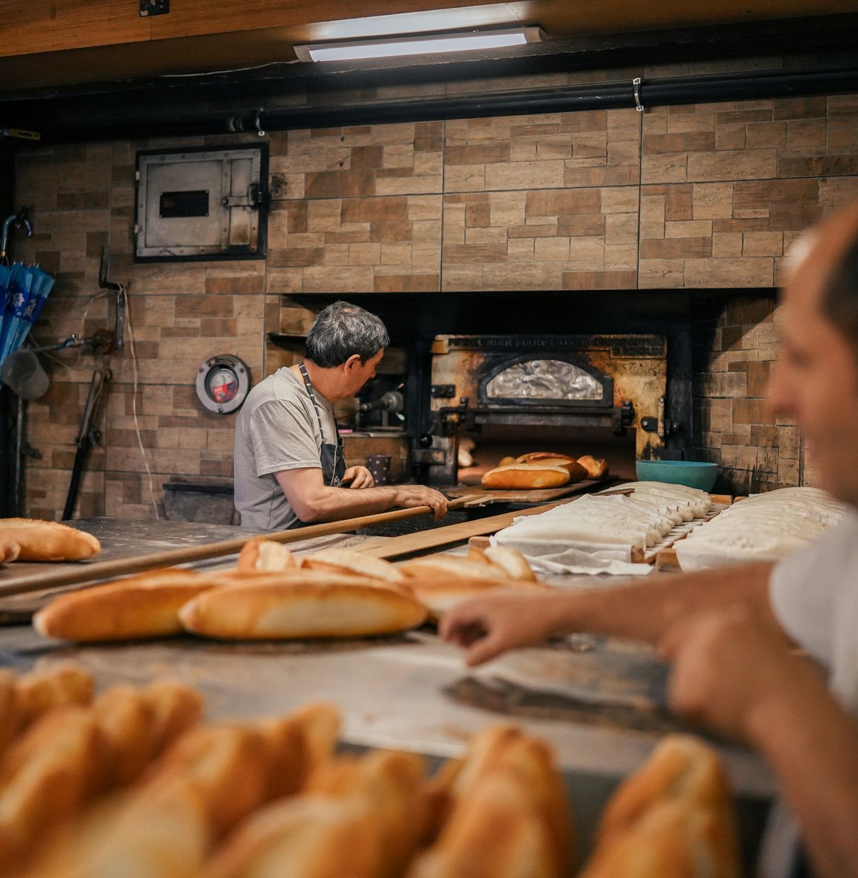 Two men are working in a bakery making bread
