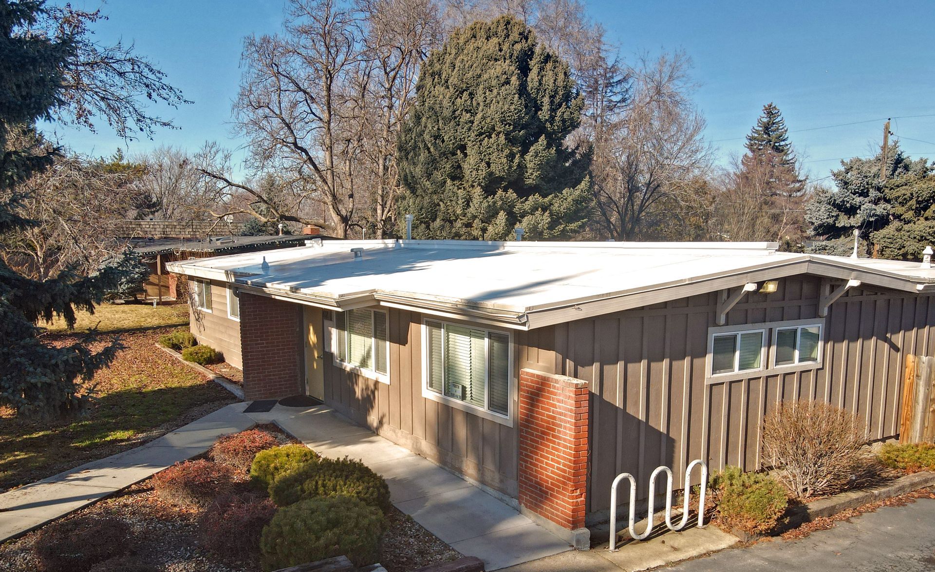 An aerial view of a house with a white roof.