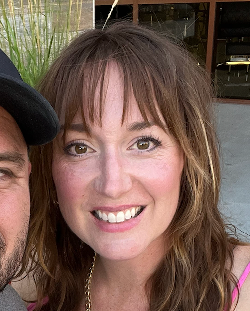 A man and a woman are posing for a picture and the woman is smiling