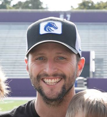 A man wearing a baseball cap with a horse on it
