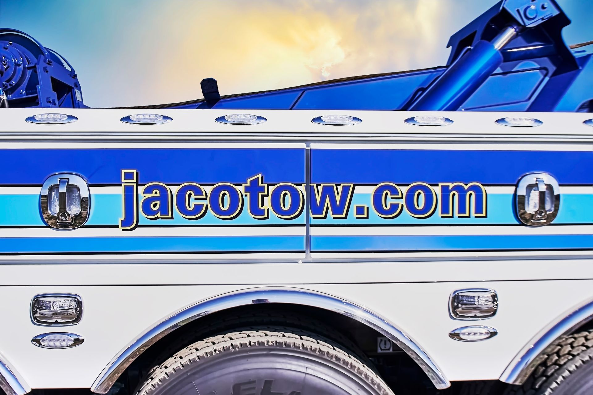 Blue tow truck with jacotow.com logo and chrome detailing