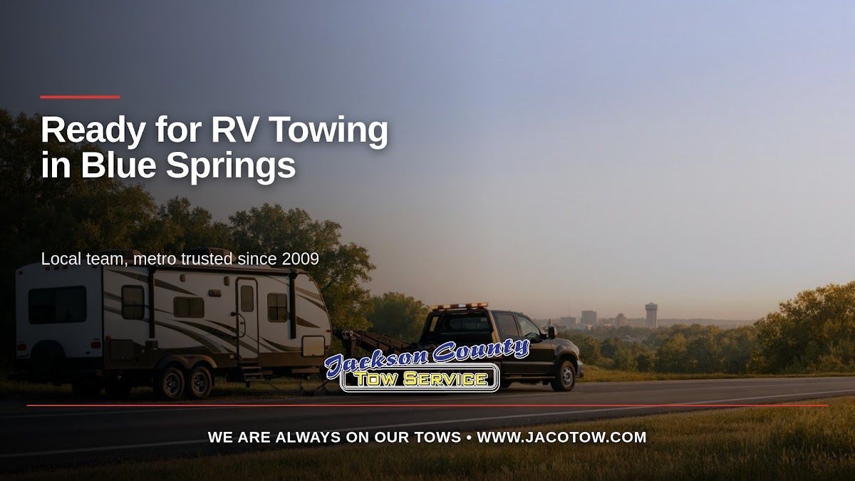A recreational vehicle beside a tow truck on a tree-lined road illustrates RV towing near Blue Springs, Missouri.