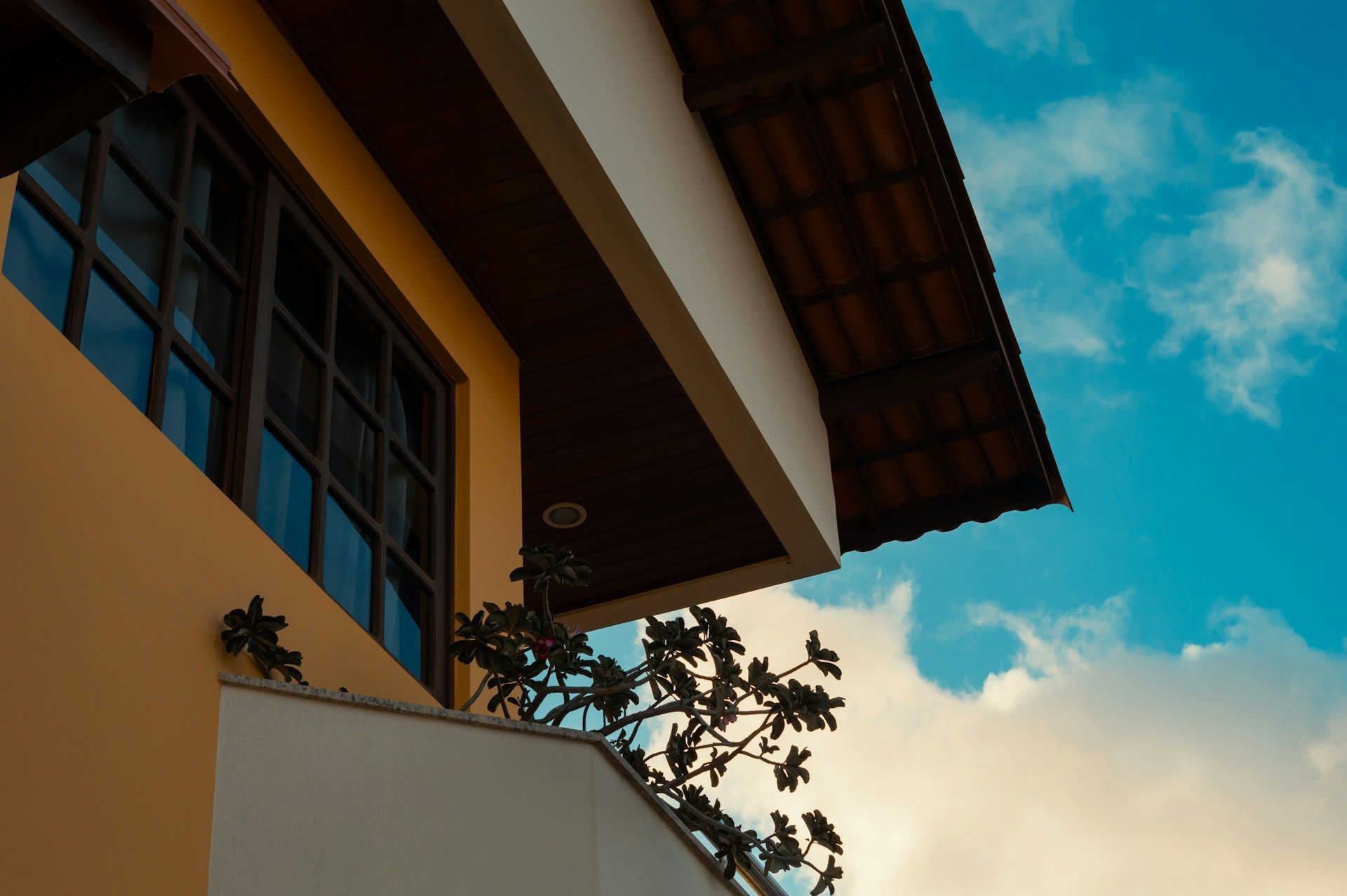 Two-story house exterior with tiled roof and balcony.