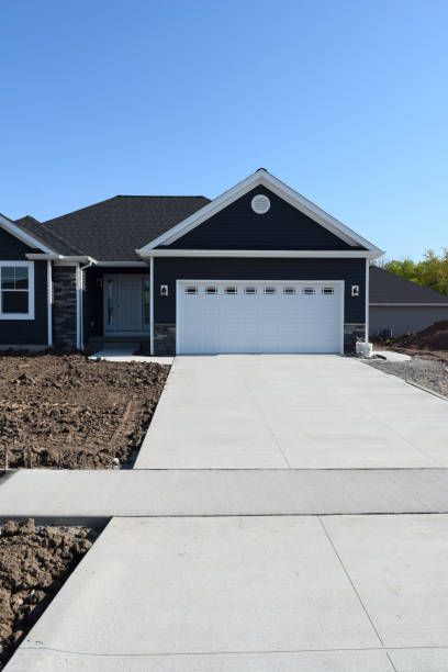 A black house with a white garage door and a concrete driveway — Canton, GA — Curb Appeal Systems