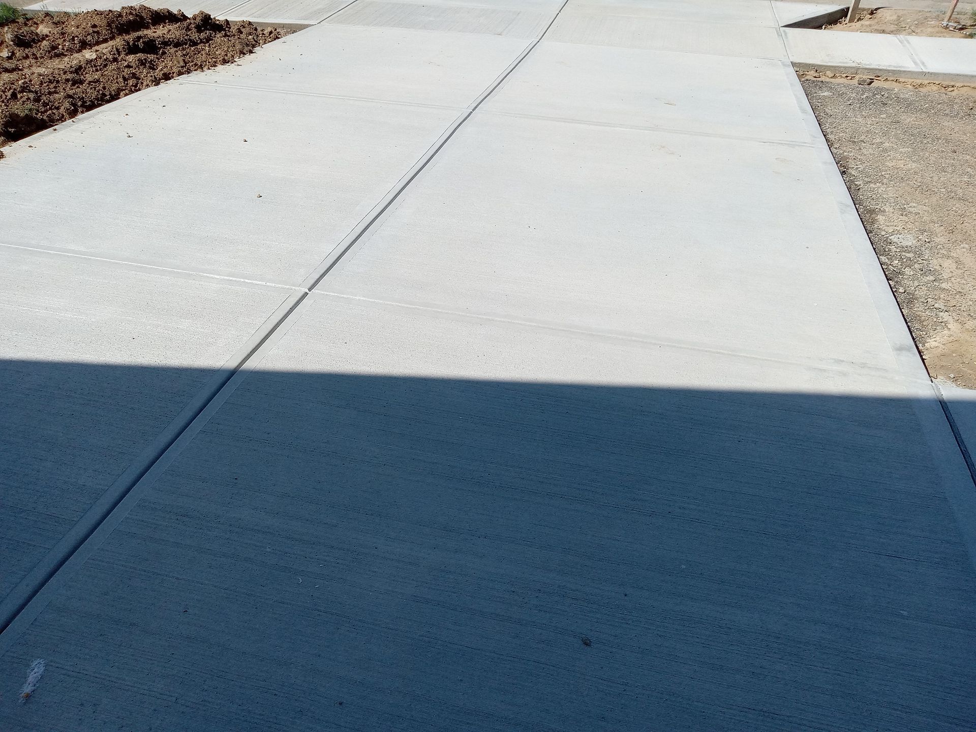 A shadow of a person is cast on a concrete sidewalk — Acworth, GA — Curb Appeal Systems