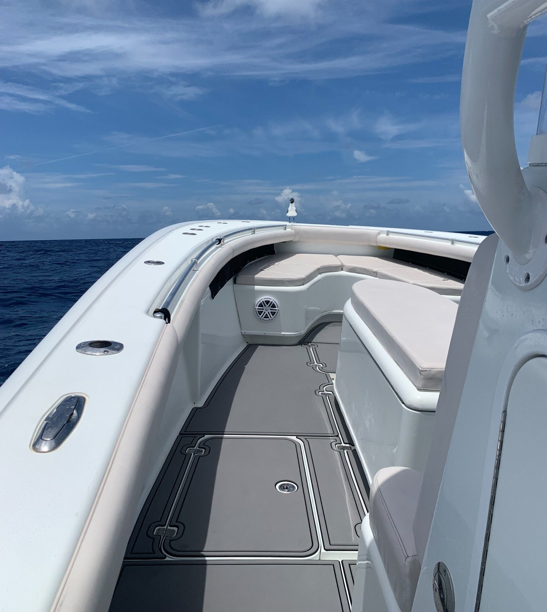 Side profile of a recreational boat underway on open ocean. White fiberglass hull and cabin visibl