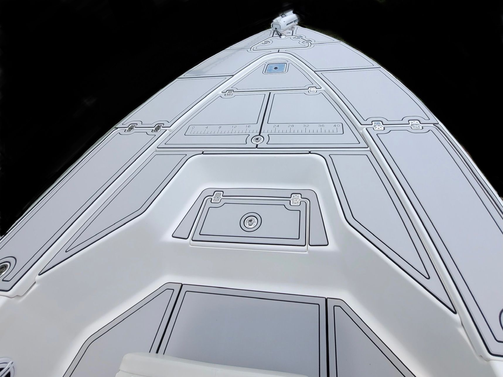 Straight-on bow view of a white center console boat showing the forward seating area with cushioned flooring.