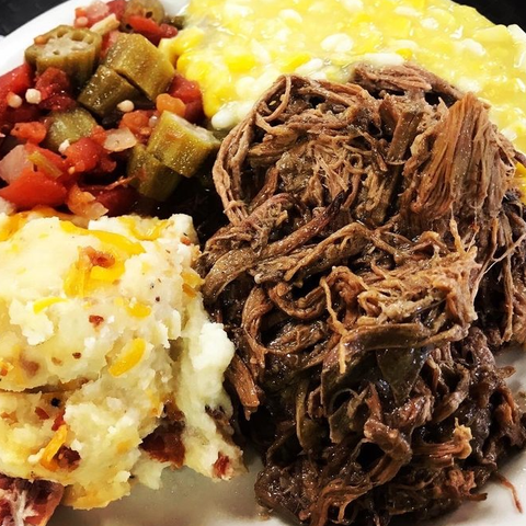 A plate of food with mashed potatoes corn and okra