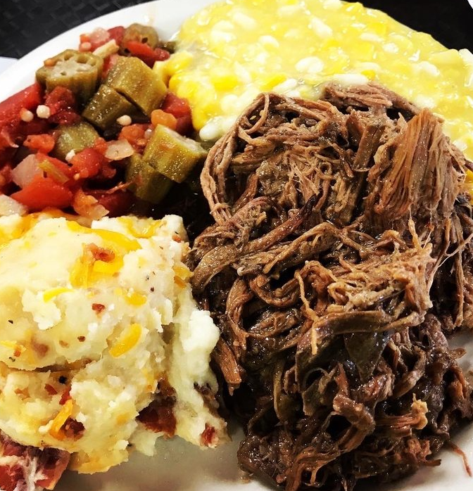 A plate of food with mashed potatoes okra corn and meat