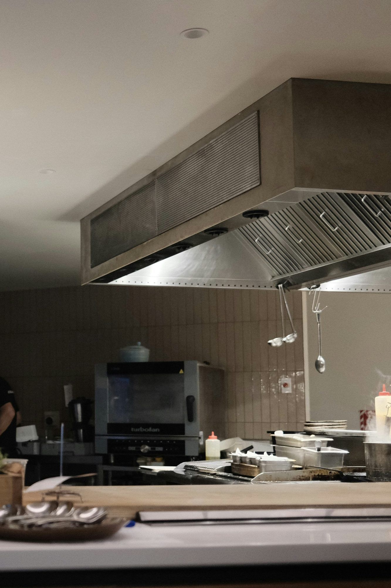 A stainless extraction canopy over a commercial range