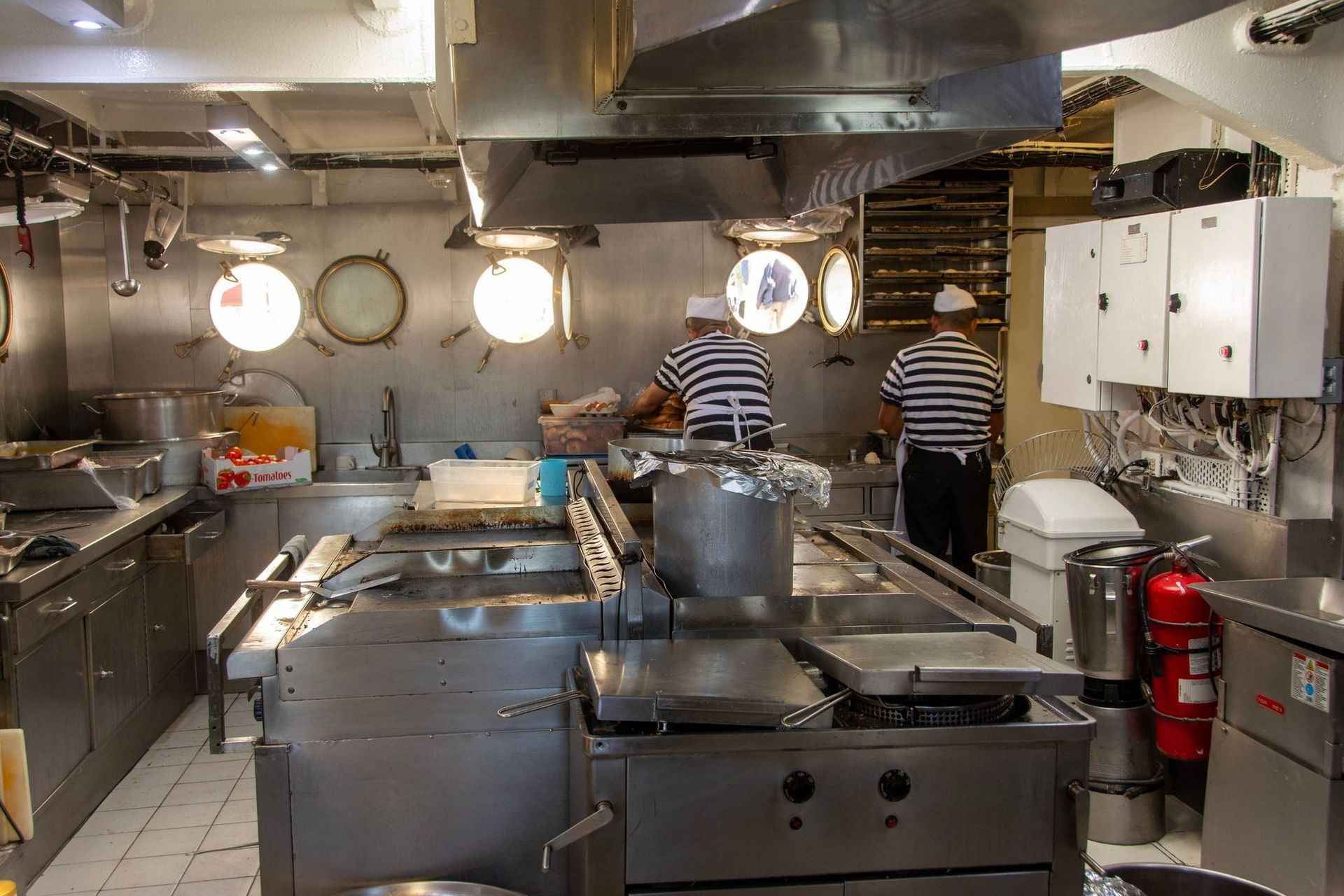 An institutional galley with cooks at the line