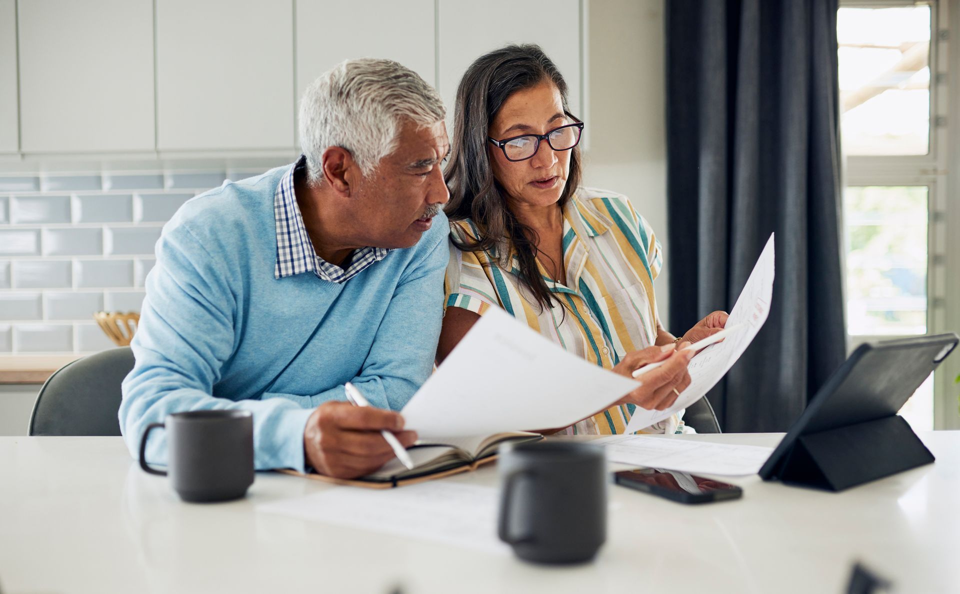 A man and a woman are sitting at a table looking at papers