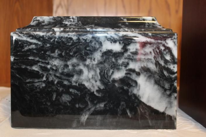 Black-and-white polished marble block with a glossy finish on a wooden surface