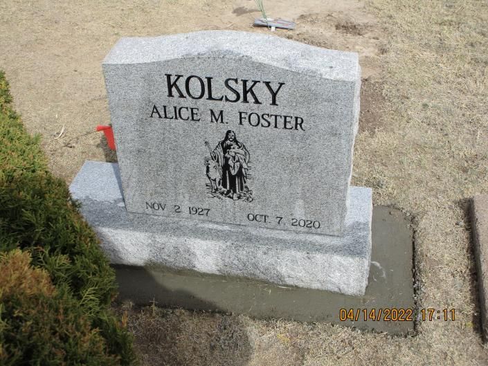 Gray granite gravestone in a cemetery, inscribed “KOLSKY” and “ALICE M. FOSTER.”