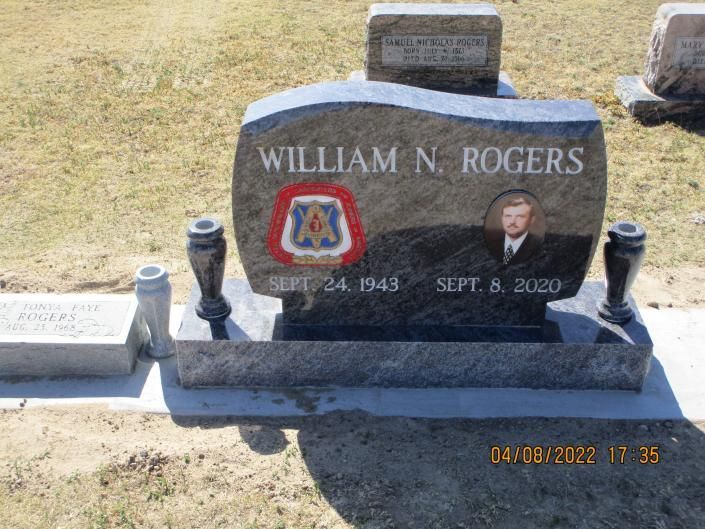Gravestone for William N. Rogers with military emblem and portrait plaque in a cemetery