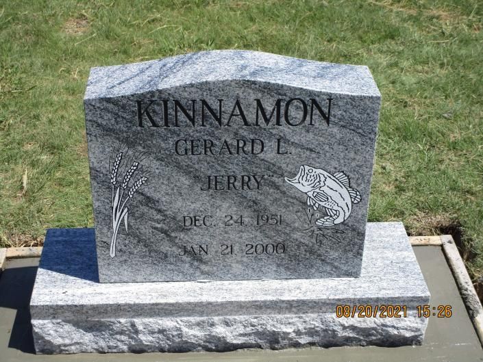 Gray granite Kinnamon family gravestone on a lawn with engraved names and dates