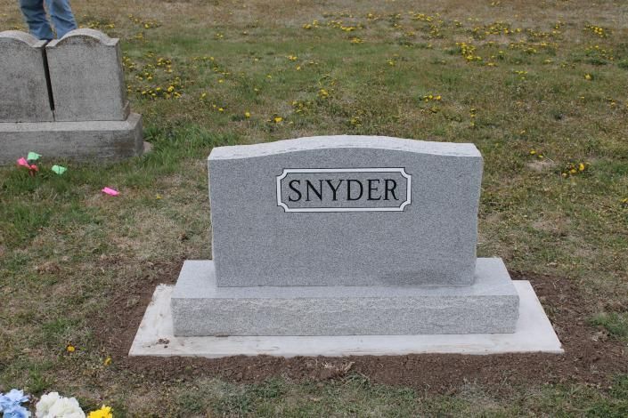 Gray gravestone with “SNYDER” plaque on a grassy cemetery plot