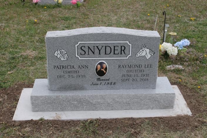Gray Snyder family gravestone in a grassy cemetery with engraved names and a central portrait medallion