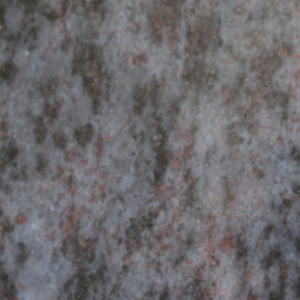 Close-up of mottled gray stone or concrete surface with pink and dark speckles
