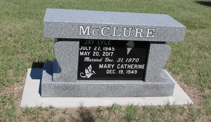 Gray McCLURE gravestone in a grassy cemetery with engraved names and dates.