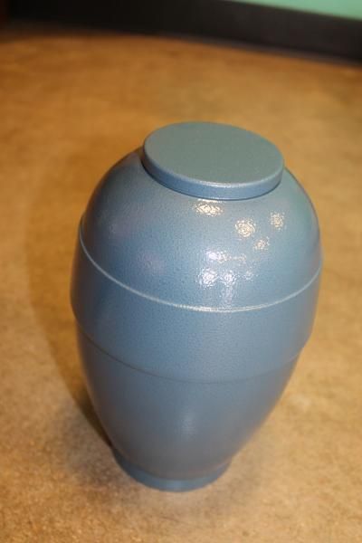 Blue urn-shaped container with a round lid on a tabletop