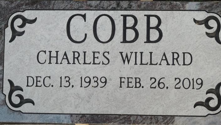 Gray memorial plaque for Charles Willard Cobb, with birth and death dates.