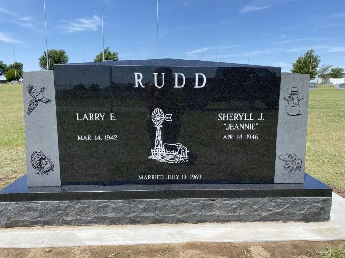 Black granite Rudd family headstone in a cemetery, with engraved names and decorative panels
