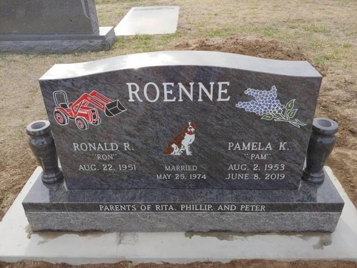 Gray gravestone with “ROENNE,” red race car and flower engravings, and two memorial plaques in a cemetery
