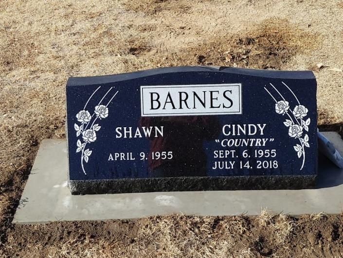 Barnes family gravestone on dry grass, with names Shawn and Cindy engraved on a dark marker.