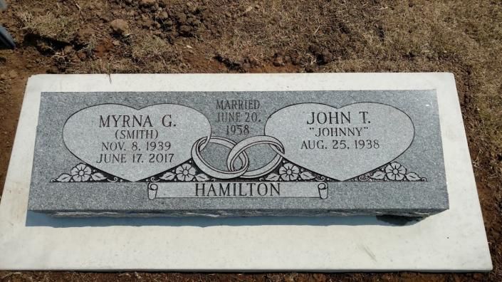 Gravestone with two oval name plaques and a wedding rings design on a gray memorial marker