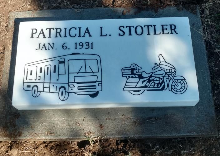 Memorial plaque reading “PATRICIA L. STOTLER, Jan. 6, 1931” with RV and motorcycle icons