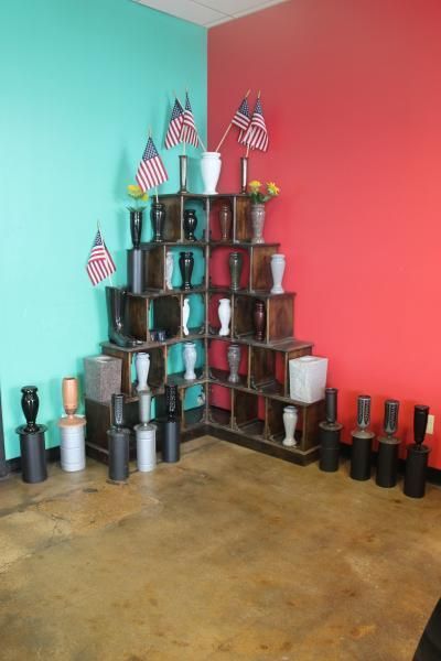 Stacked cups and small American flags arranged like a pyramid against turquoise and coral walls.