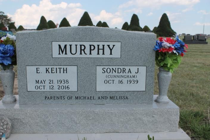 Gray Murphy gravestone with floral arrangements in a cemetery