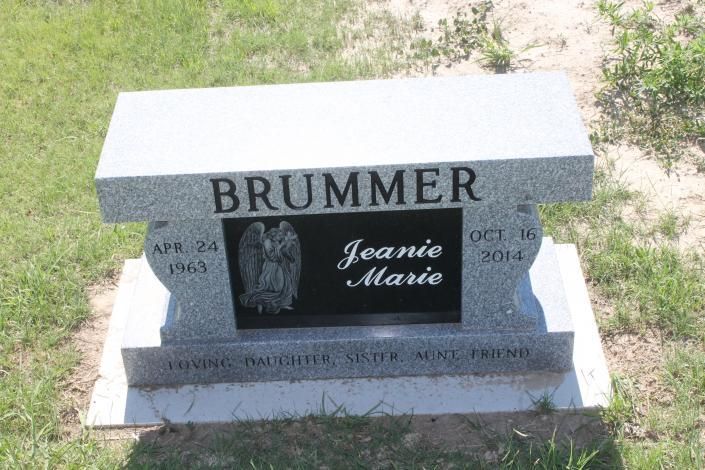 Gray tombstone in grass engraved “BRUMMER” with a black portrait plaque and “Jeanie Marie” inscription