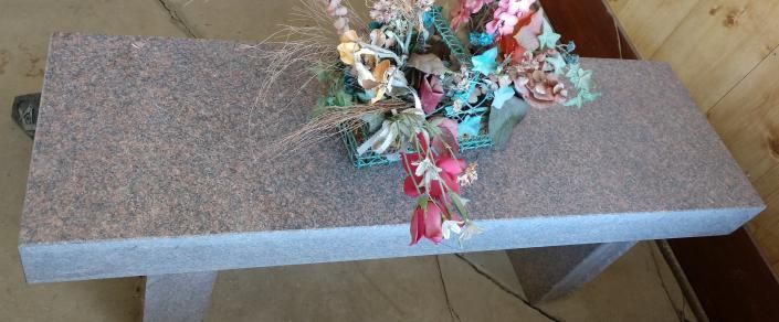 Gray rectangular foam board with a small pile of colorful shredded ribbon tied near the center
