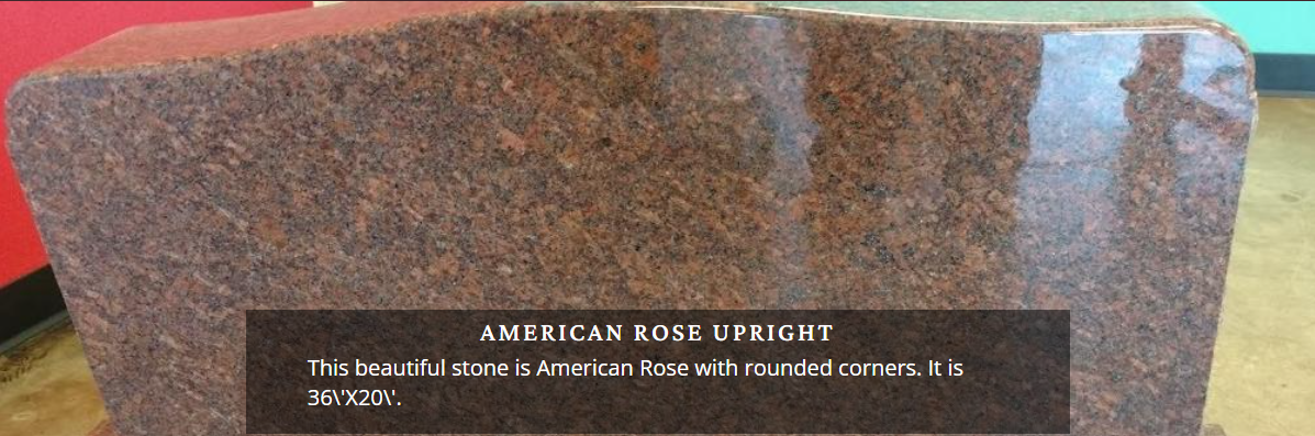 Bronze memorial plaque on a polished red granite stone monument outdoors