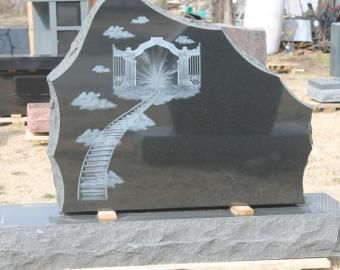Black polished gravestone with etched stairway, gate, and clouds