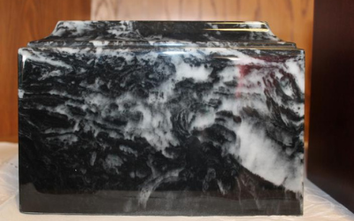 Black and white marbled rectangular stone block on a tabletop against a wood-paneled background