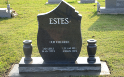 Black granite ESTES gravestone with two urns on a grassy cemetery plot