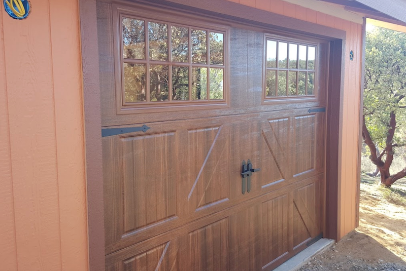 A Wooden Garage Door with A Window on The Side of A House.