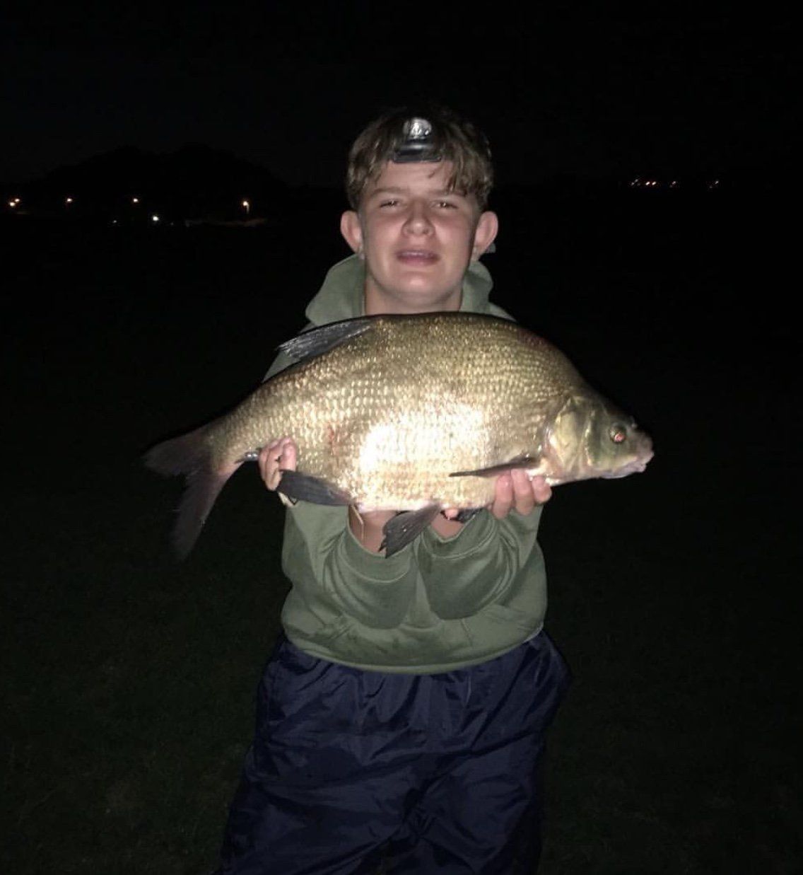 A boy catches a big fish at our holiday park in Somerset