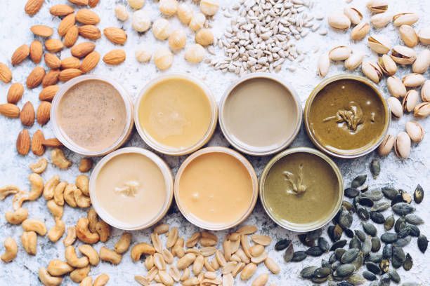 There are many different types of peanut butter and nuts on the table