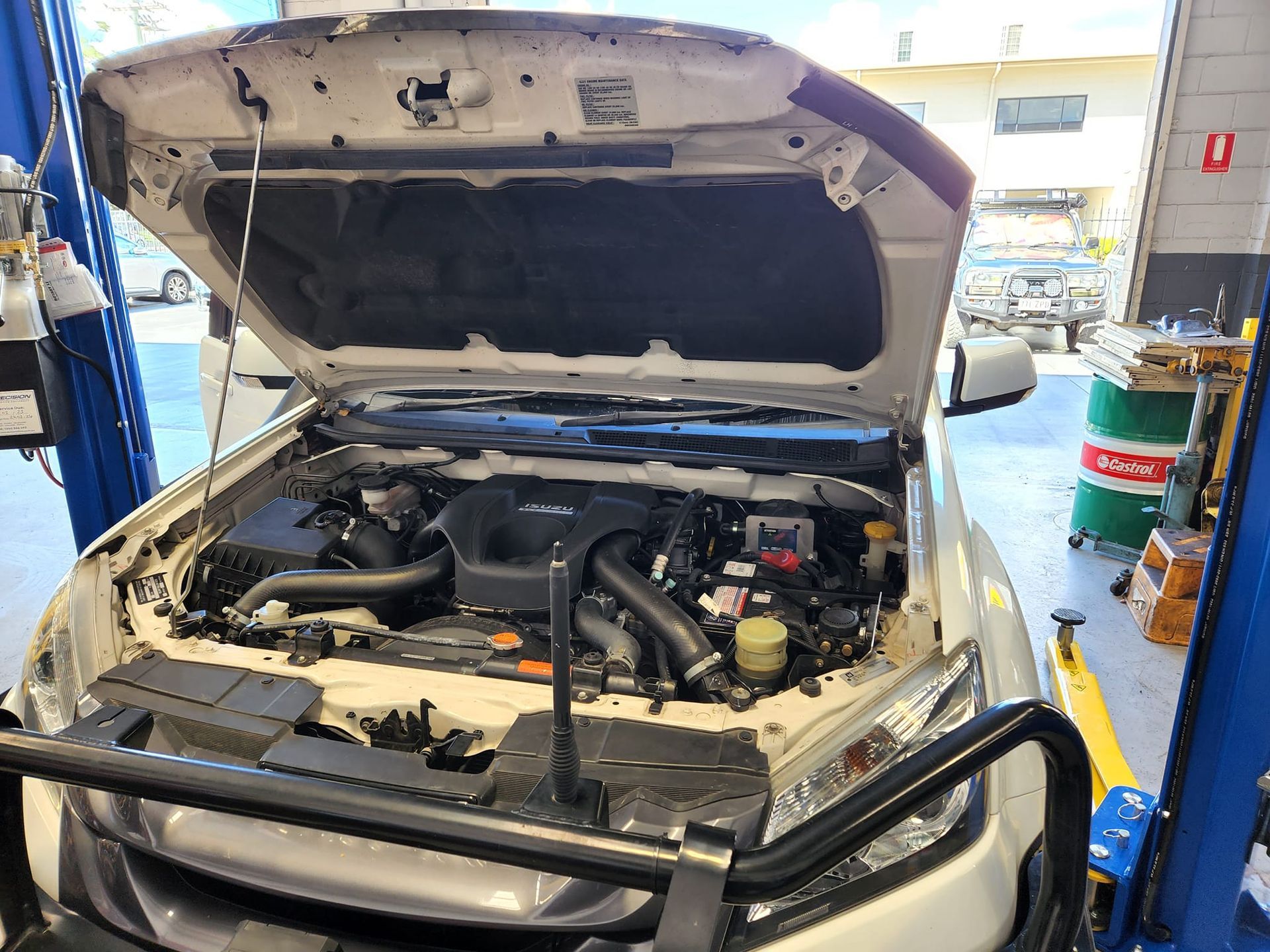A White Truck With the Hood Open is Sitting on a Lift in a Garage — GZM 4x4 Performance In Gold Coast, NSW