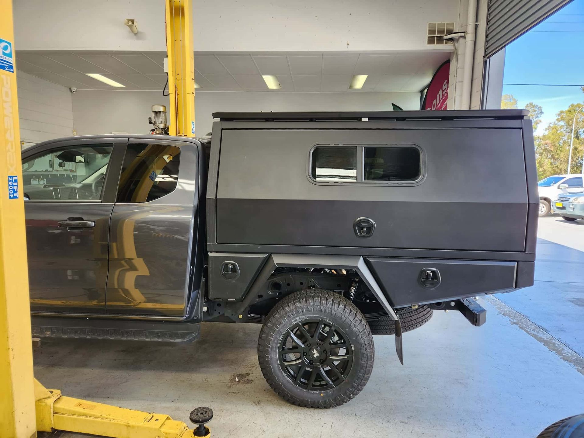 A Black Truck is Parked on a Lift in a Garage — GZM 4x4 Performance In Gold Coast, NSW