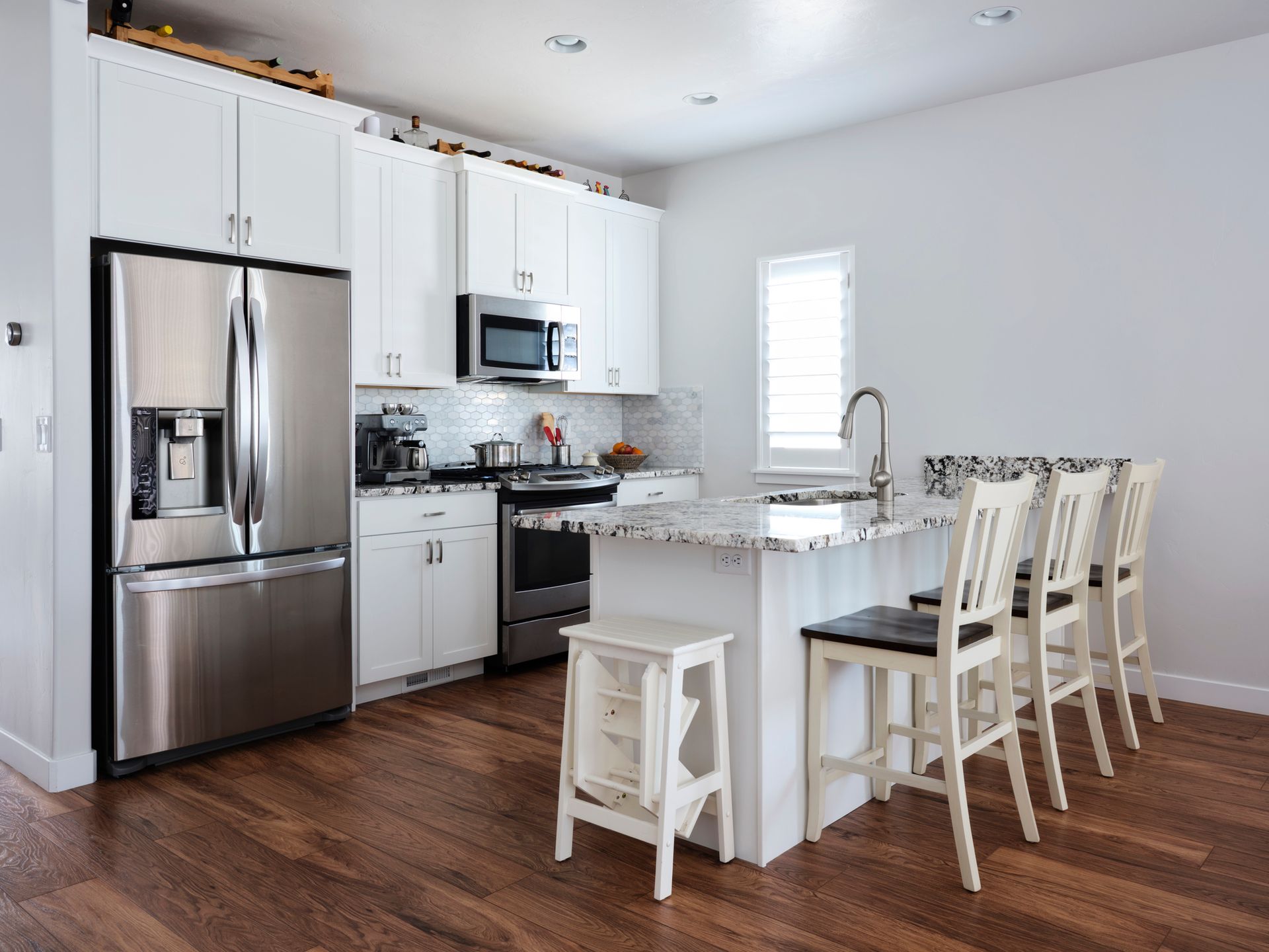 A kitchen with stainless steel appliances and white cabinets - Wivenhoe, TAS - Summers Floors Pty Ltd